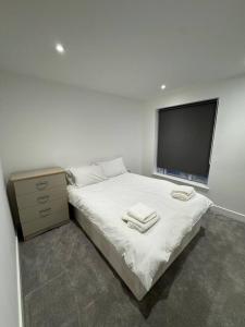 a bedroom with a bed and a dresser and a television at Tranquil 3BD in Watford in Watford