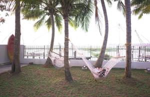 a person laying in a hammock between two palm trees at Kumarakom Homes in Kumarakom +3 photos