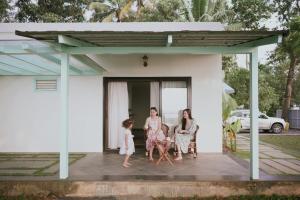 a family sitting on the porch of a house at Kumarakom Homes in Kumarakom