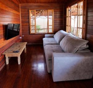 a living room with a couch and a table at Pousada Estância Pontello - próximo ao aeroporto de Confins in Confins