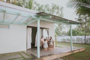 a family sitting on a porch of a house at Kumarakom Homes in Kumarakom