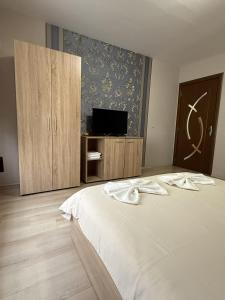 a bedroom with a white bed and a tv at Guest House STEVi in Devin