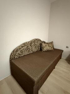 a brown couch with two pillows on it in a room at Guest House STEVi in Devin