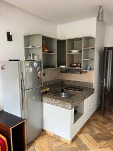 a kitchen with a refrigerator and a sink at Guest house in Imsouane