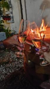 two people holding wine glasses in front of a fire at Villa do Condado in Saquarema +25 photos