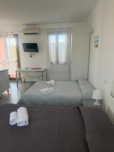 a bedroom with two beds with towels on them at Aurasol Alghero in Alghero