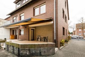 ein Backsteinhaus mit einer Terrasse mit einem Tisch darauf in der Unterkunft Apart2Stay Dormagen in Dormagen