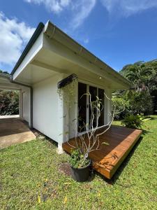 a house with a wooden deck in the yard at Panorama Bungalow in Tahaa