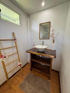 a bathroom with a sink and a mirror at Panorama Bungalow in Tahaa