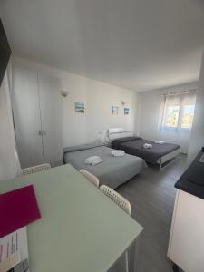 a room with two beds and a table at Aurasol Alghero in Alghero