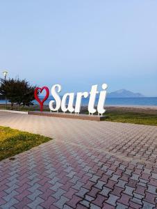 a sign for a sarti sign on a sidewalk at Farma Giannis in Sarti