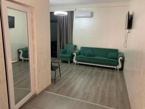 a living room with a green couch and a mirror at Kobuleti hotel 656 in Kobuleti