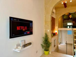a television on a wall in a living room at Dar Divinus - Eat, Wine, Sleep in Rabat