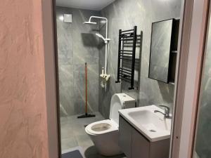 a bathroom with a white toilet and a sink at Kobuleti hotel 656 in Kobuleti +5 photos