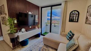 a living room with a large television and a couch at Apartamento con vistas, balcón, gym y parking in Tegucigalpa