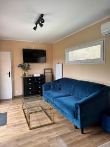 a living room with a blue couch and a tv at Domki La Bella 3 in Aleksandria