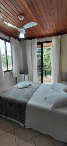 a bedroom with a bed and a ceiling fan at Pousada Costa do Sol in Aracruz