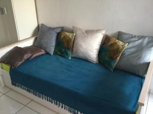 a couch with several pillows on top of it at studio Rony in Port-Louis