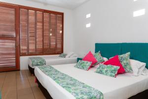 two beds in a room with windows at Hotel Chiniu in Palomino