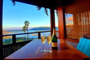 a bottle of champagne and two glasses on a table at Paradise Private Zen Studios in Knysna +70 photos
