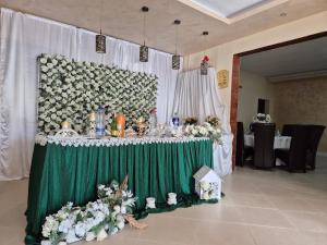 a table with a green table cloth and flowers on it at Pensiunea Vila Maria in Crăcăoani +131 photos
