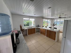 a large kitchen with a counter and some windows at Grand Panorama Villa in Tahaa