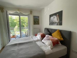 a bed with pillows on it in a room with a window at Appartement Eveline Pörtschach in Pörtschach am Wörthersee