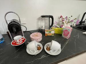 a counter top with three cups and plates on it at Appartement Eveline Pörtschach in Pörtschach am Wörthersee