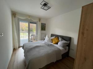 a bedroom with a bed with white sheets and yellow pillows at Appartement Eveline Pörtschach in Pörtschach am Wörthersee +27 photos