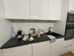 a kitchen with white cabinets and a black counter top at Appartement Eveline Pörtschach in Pörtschach am Wörthersee