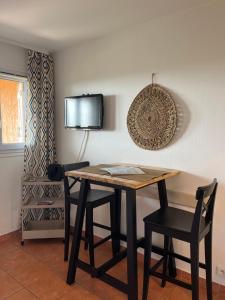 a dining room table with two chairs and a tv at Côte d azur Magnifique studio in Les Issambres