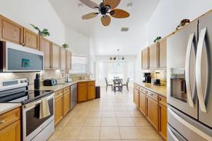a kitchen with wooden cabinets and a ceiling fan at Sebastian Serenity in Sebastian