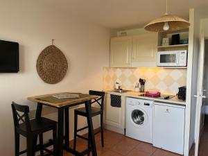 a kitchen with a table and a washing machine at Côte d azur Magnifique studio in Les Issambres