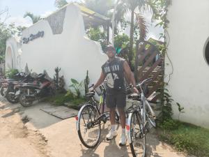 a man is standing next to his bike at Hugo Homestay in Phong Nha