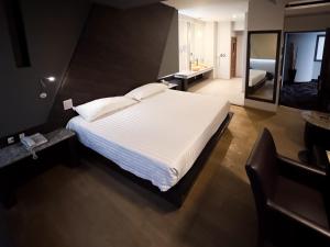 ein Schlafzimmer mit einem großen weißen Bett und ein Badezimmer in der Unterkunft La Moraleja Love hotel in Mexiko-Stadt