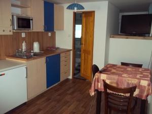 a kitchen with a table and a kitchen with a television at Penzion Apartmány Zlín in Zlín