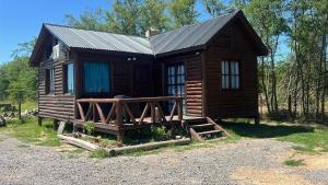 a log cabin with a metal roof and a porch at La Escondida in Estación Monte