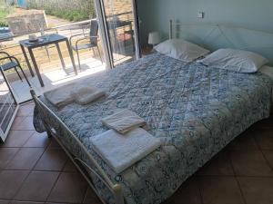 a bed with towels on it in a room with a window at Olympic View Guesthouse in Kalami