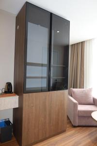 a large glass cabinet in a living room with a chair at Palmero Butik Otel in Çiftlikköy
