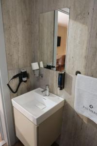 a bathroom with a white sink and a mirror at Palmero Butik Otel in Çiftlikköy +4 photos