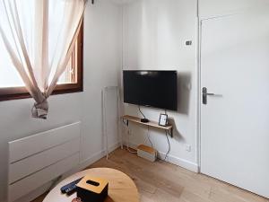 a room with a flat screen tv on a wall at Studio cosy tout équipé, idéal in Chilly-Mazarin