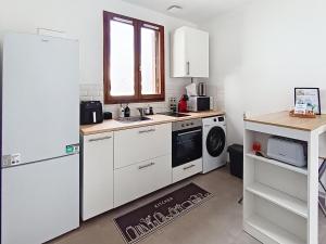 a kitchen with a white refrigerator and a dishwasher at Studio cosy tout équipé, idéal in Chilly-Mazarin