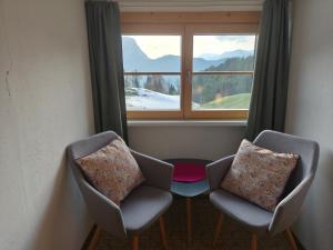 two chairs sitting in front of a window at Berghotel Hinterduxerhof in Sparchen