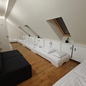 a row of white beds in a room at Mazurek Balatonboglar in Balatonboglár +76 photos