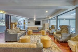 a living room with couches and chairs and a tv at SureStay Plus Hotel by Best Western Reno Airport in Reno