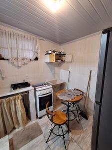 a kitchen with two chairs and a table and a stove at Flat Serrano in Miguel Pereira