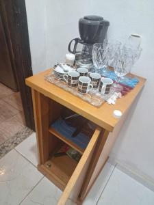a table with cups and wine glasses on it at Flat Serrano in Miguel Pereira