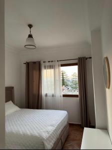 a bedroom with a bed and a window at Luxushaus in Martil
