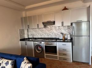 a kitchen with stainless steel appliances and a blue couch at Luxushaus in Martil