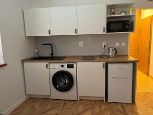 a kitchen with a washing machine and a microwave at Nido in the center in Poprad